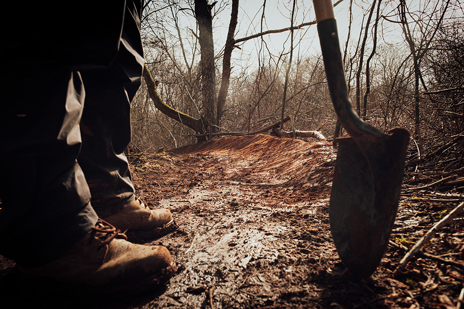 person with shovel in woods