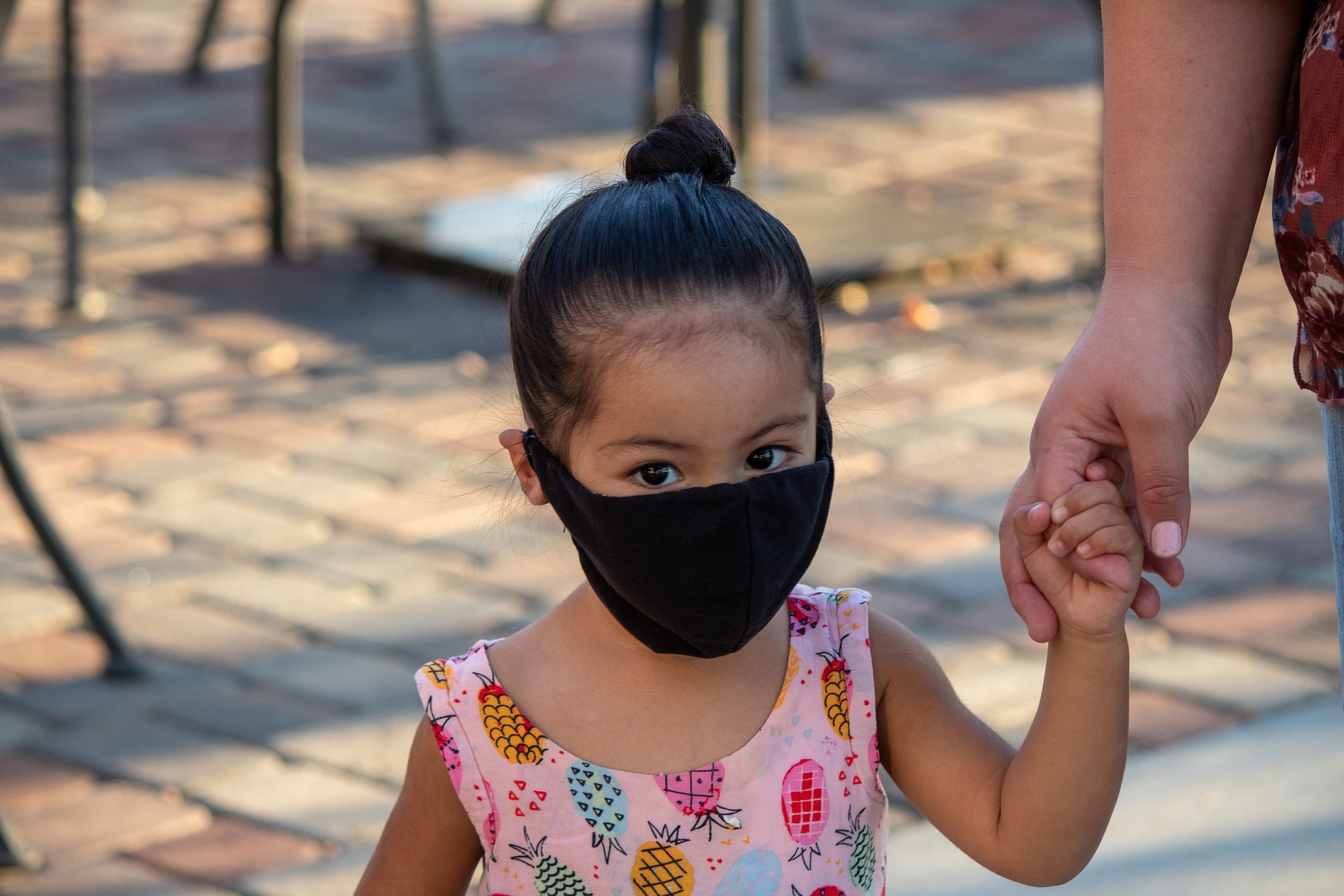 A toddler with a black mask on