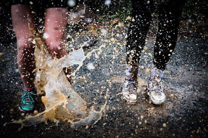 people's feet splashing in muddy water