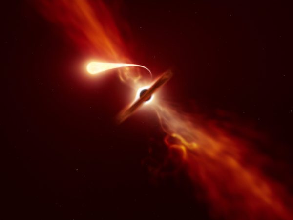 This illustration depicts a star (in the foreground) experiencing spaghettification as it's sucked in by a supermassive black hole (in the background) during a 'tidal disruption event'.
