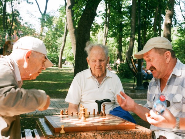older adult men playing chess together