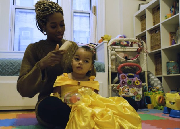 Bianca Jones Marlin brushing her daughter's hair in a playroom