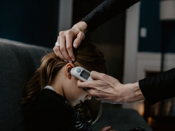 A woman checking a child's temperature