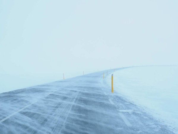 An image of a road covered in snow during a blizzard.