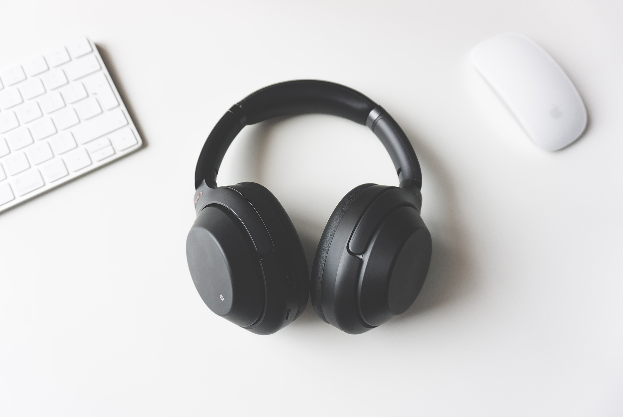 headphones, keyboard, and mouse on a white surface