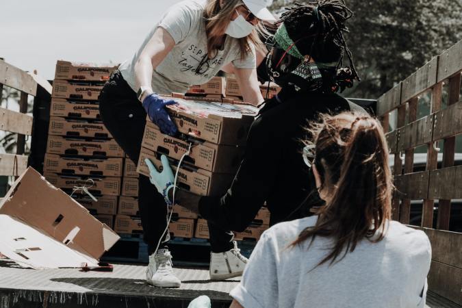 Volunteers gathering food off of a truck.