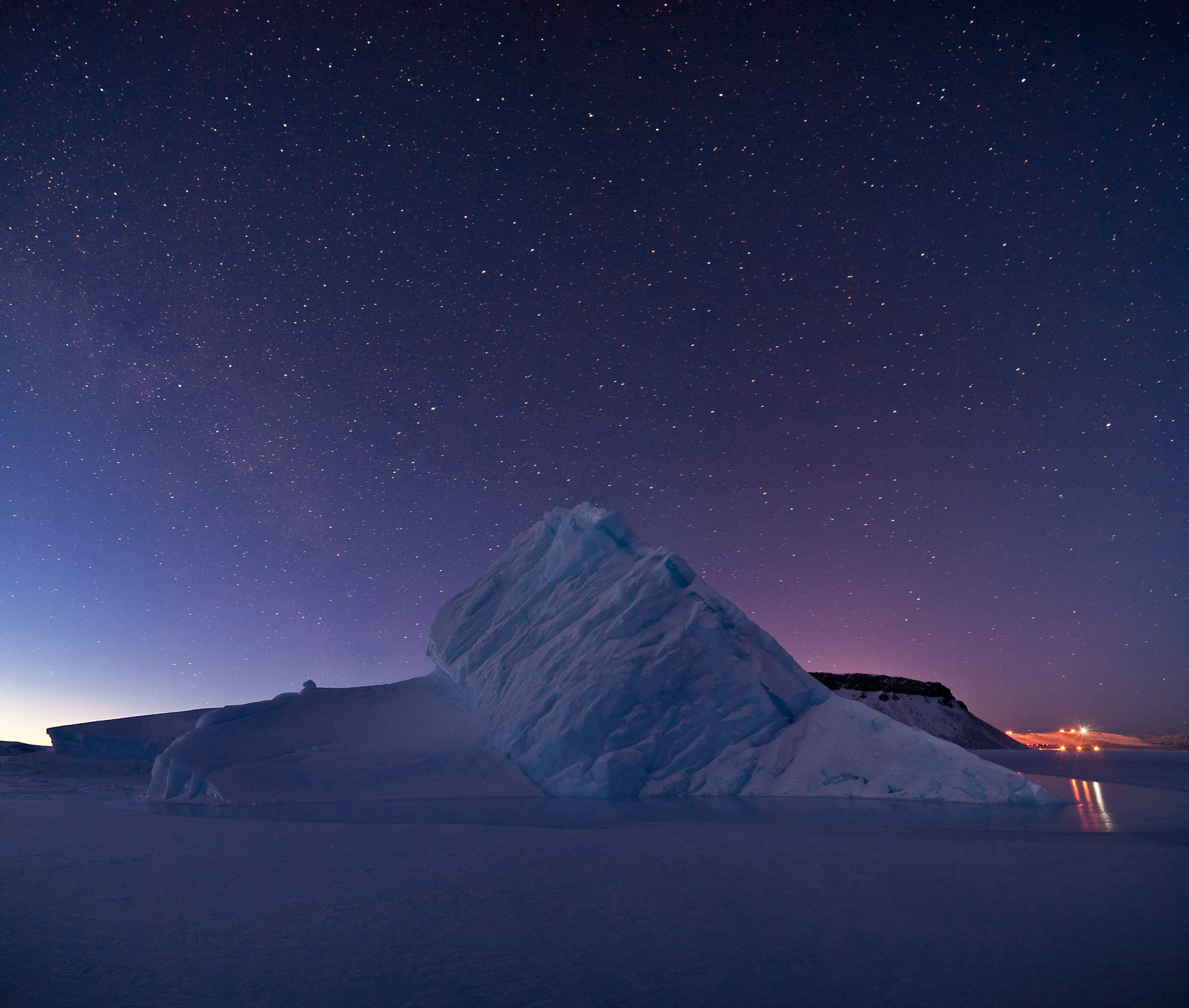 The starry Arctic sky over an iceberg in Greenland