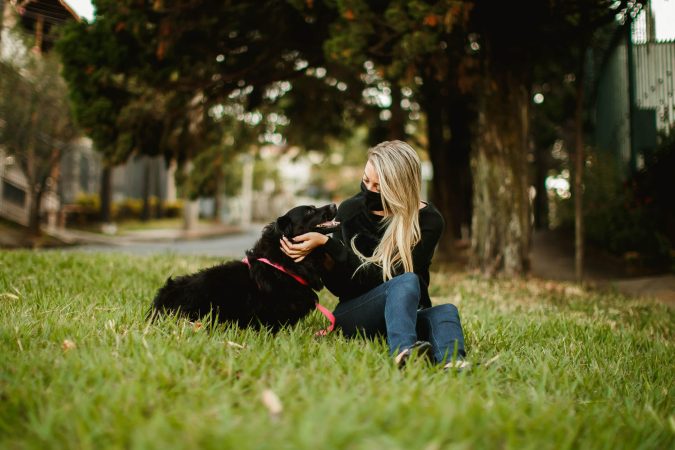 Woman in mask with dog.