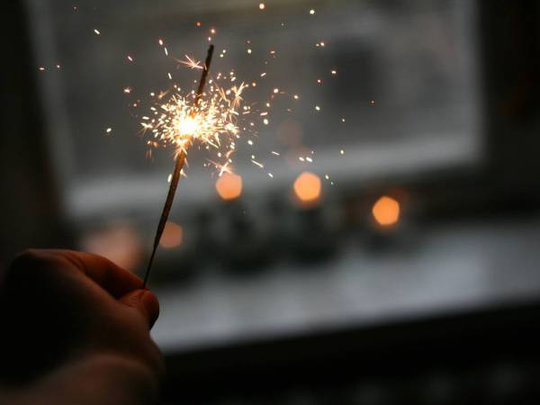 Hand holding a fire work in the dark