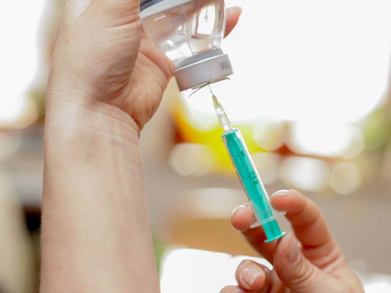 a person putting a vaccine into a syringe.