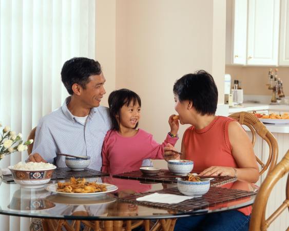 Chinese parents and kid have a meal in their dining room