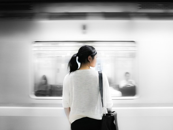 a woman getting ready to get on a mass transit subway