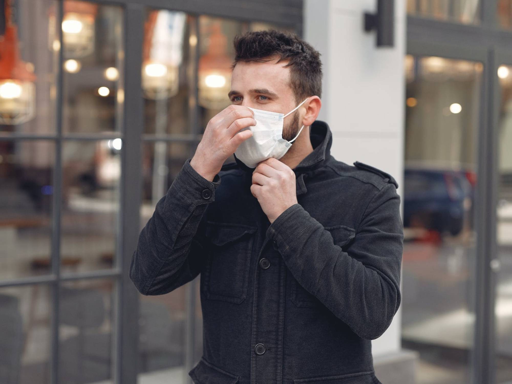 Bearded man wearing a surgical mask on the street