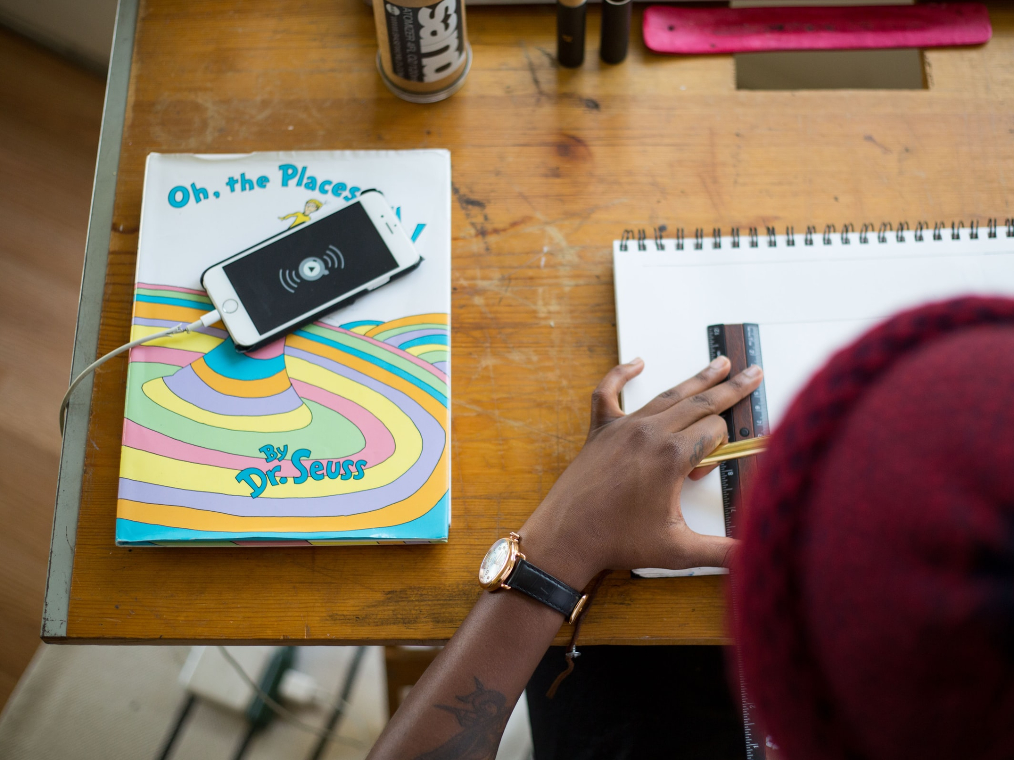 iPhone with a lithium-ion battery charging on a cord on a Dr. Seuss book