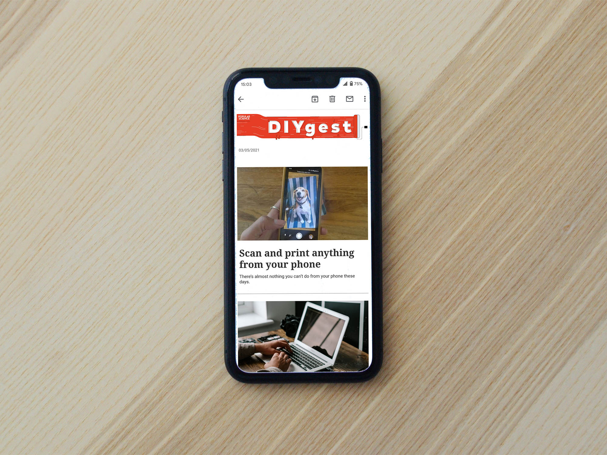 iPhone on a wooden table with a newsletter on the screen
