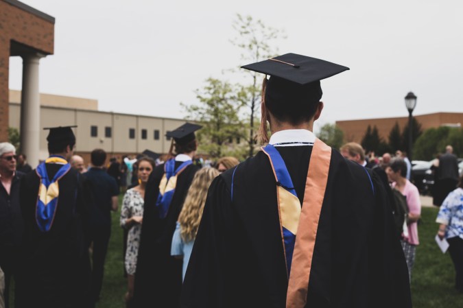 people at a graduation ceremony wearing caps and gowns outside