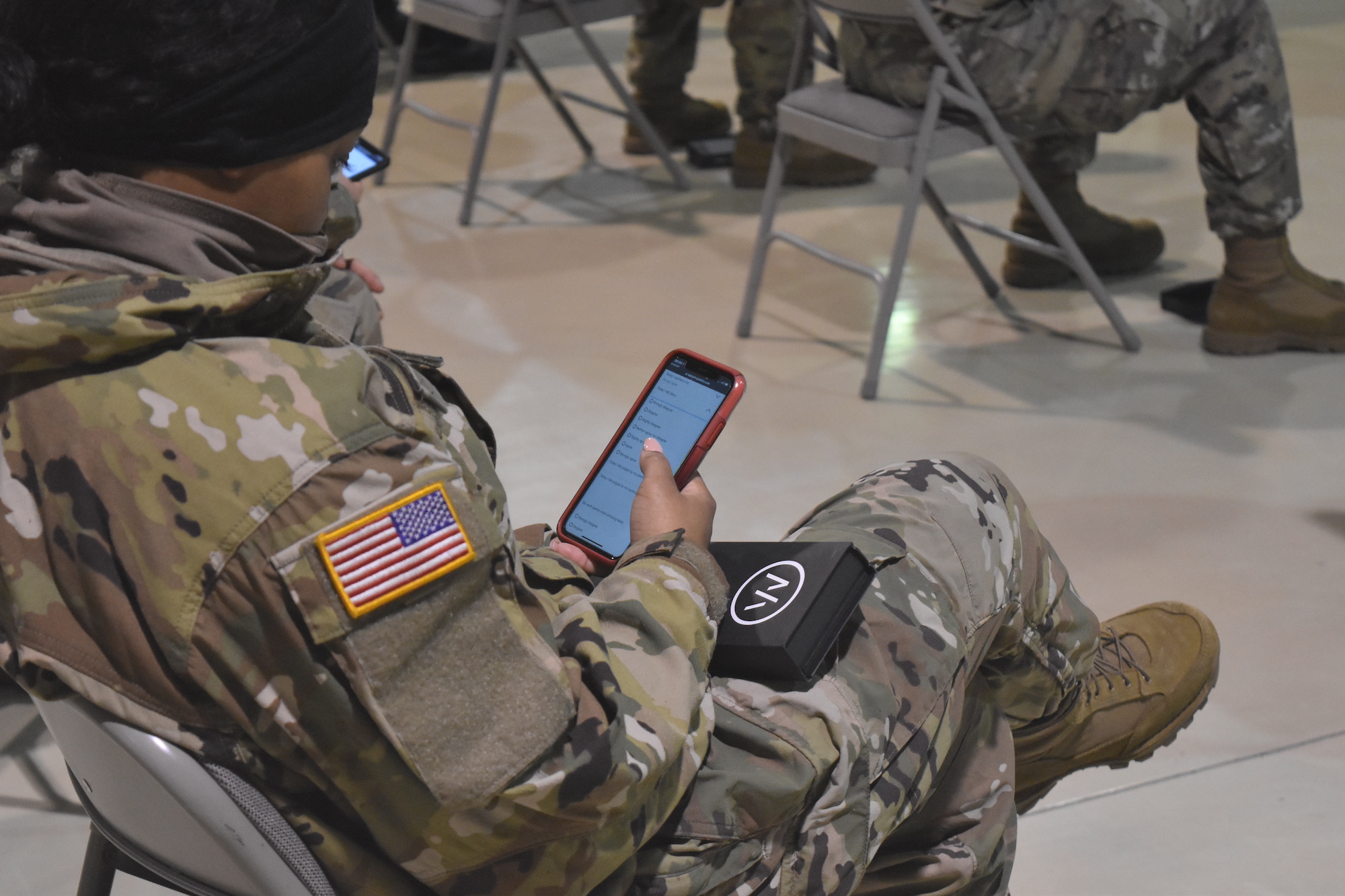 A soldier holds a smartphone.