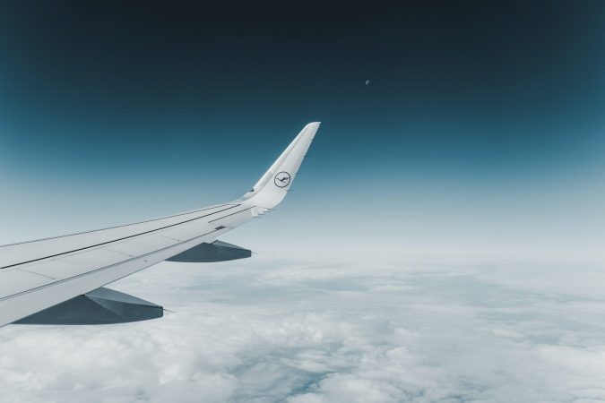 Airplane wing in flight with clouds