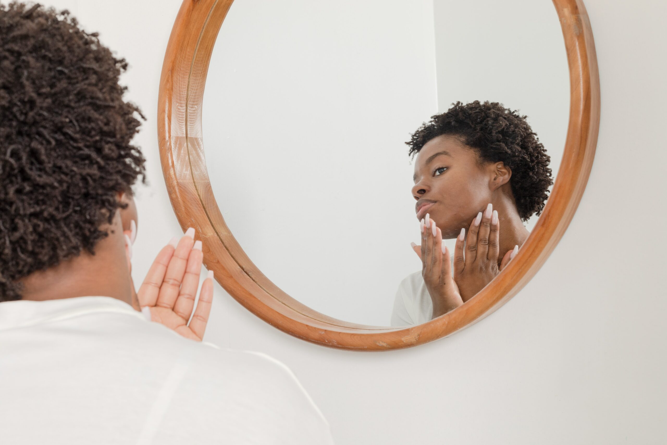 Woman applying lotion in mirror