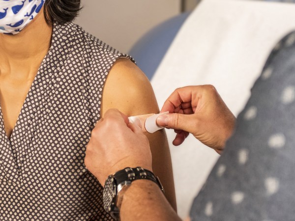 doctor putting bandaid on arm after person gets a vaccine