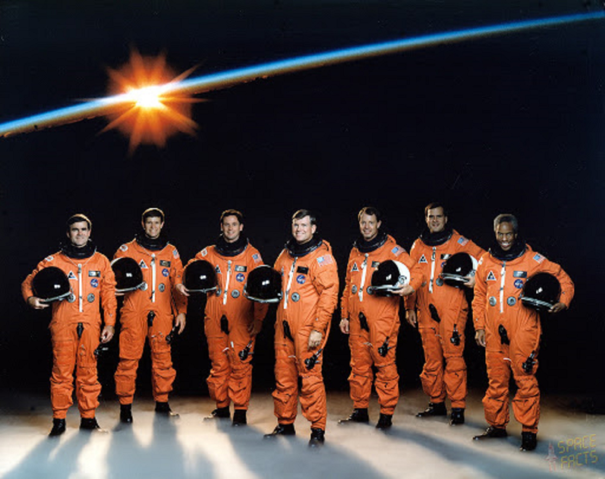 The NASA STS-39 shuttle crew in orange astronaut suits on a space backdrop
