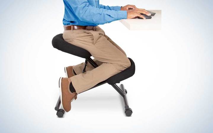  A person sitting on a ProErgo kneeling chair for short people on a plain background.