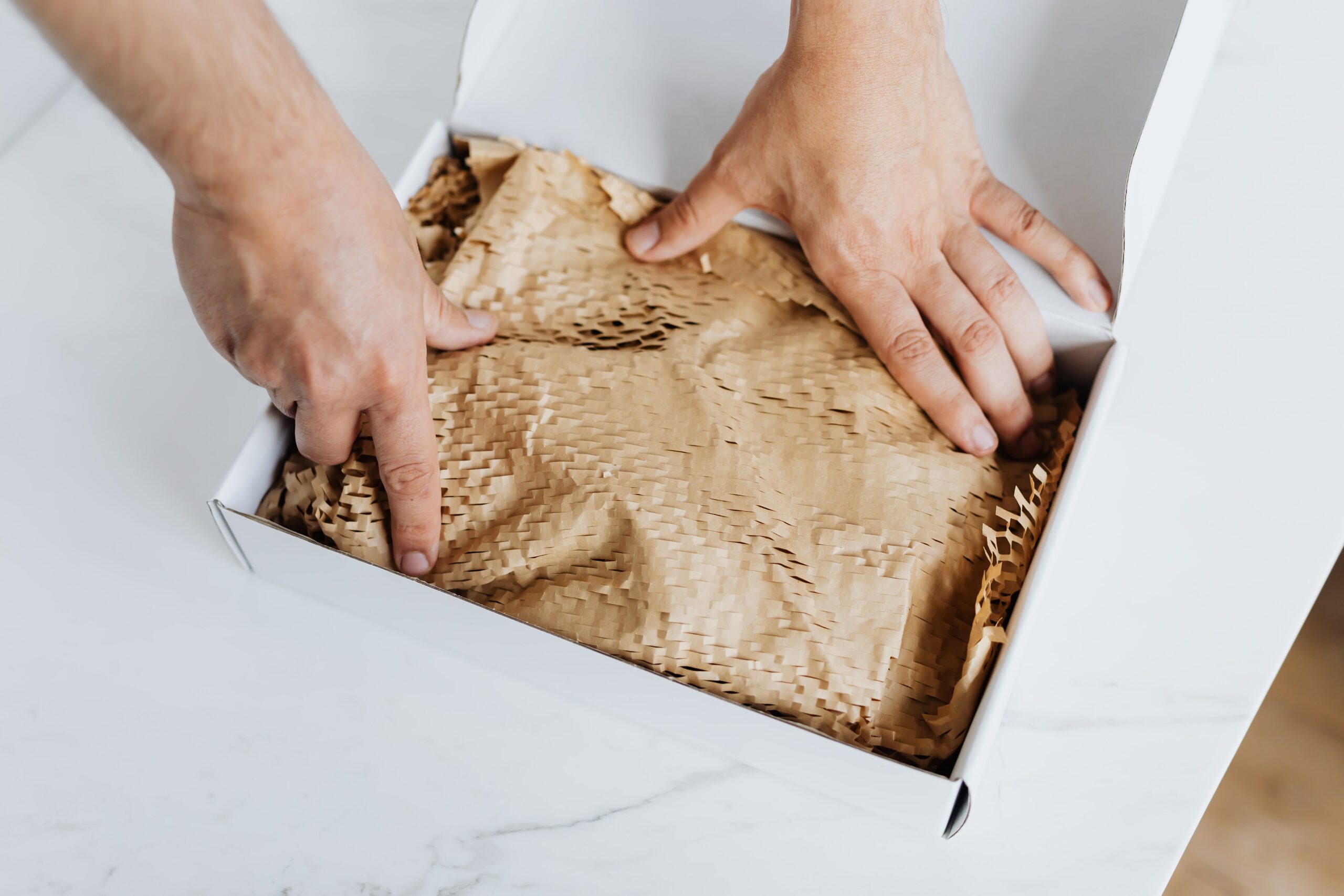 guy reaching into a box with brown filling in it