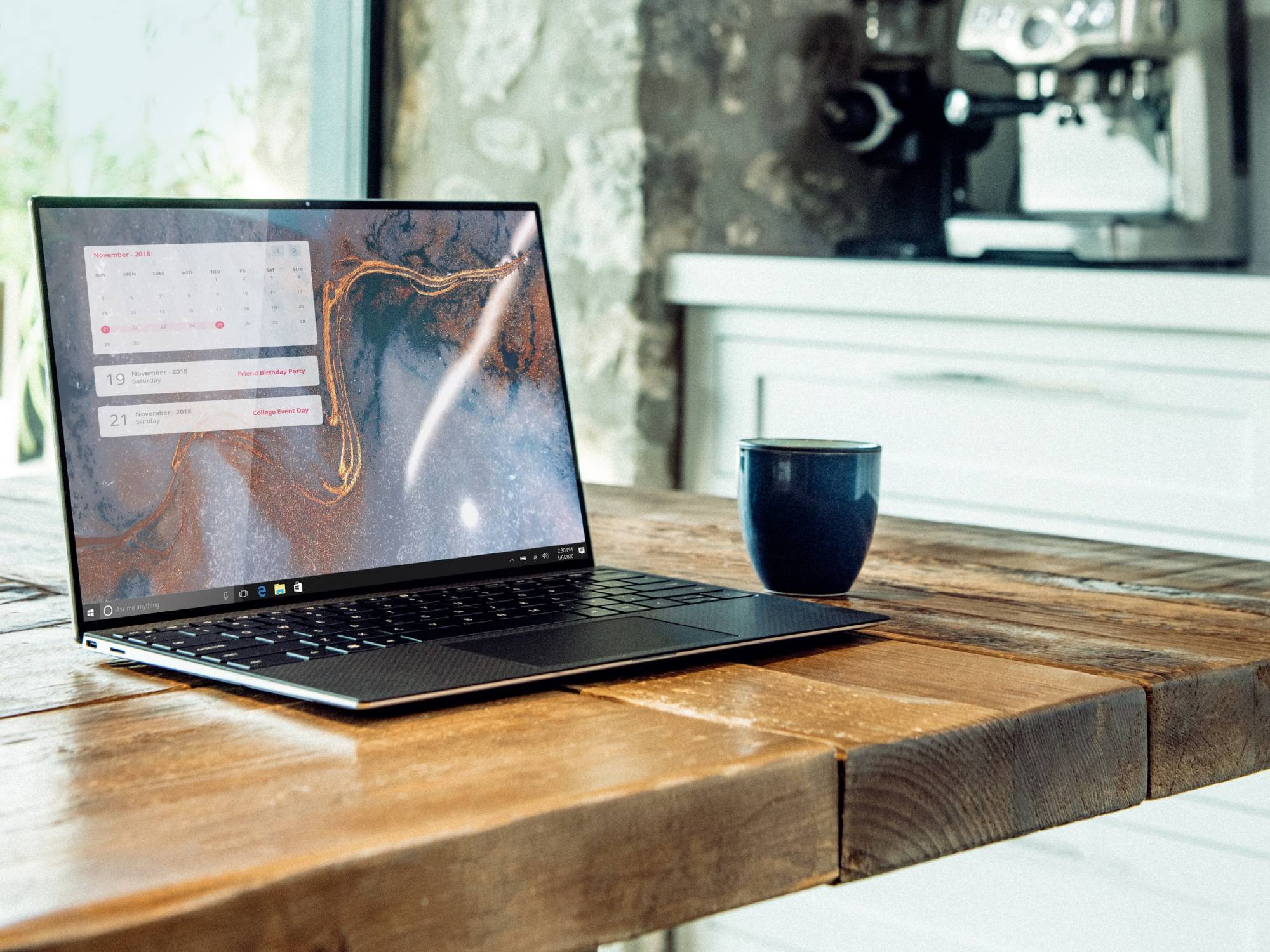 A Dell laptop compatible with Windows keyboard shortcuts on a wooden table with a coffee mug beside it.