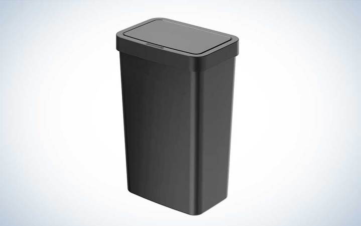 A black plastic trash can on a plain background.