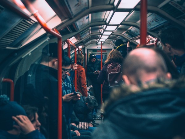 A person using a phone on a crowded subway train.