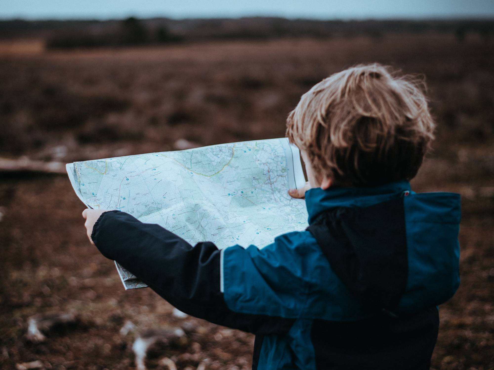 A child holding a map outdoors.