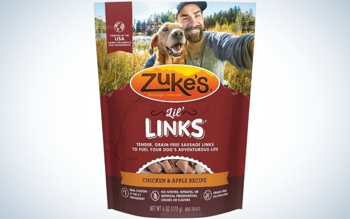  AZuke's Lil' Links Grain Free Dog Treats Chicken & Apple recipe in a cherry-colored packaging and with a picture of a man by his side with his dog.