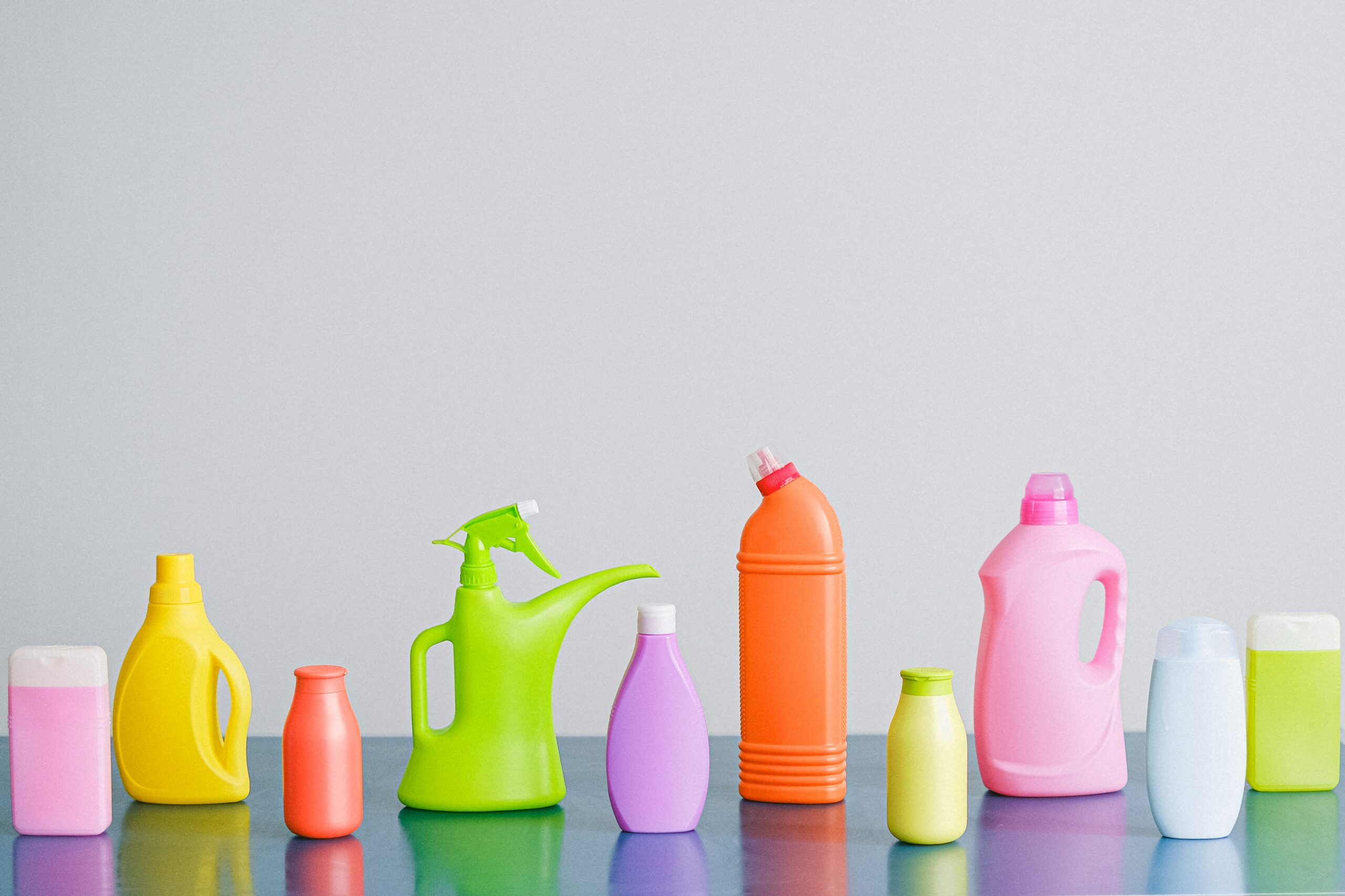 Colorful cleaning products on blank background.