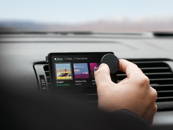 A person controls a knob on Spotify's Car Thing device.