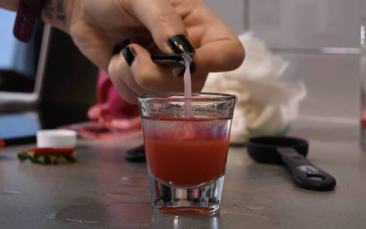 Hand with tweezers collecting strawberry DNA