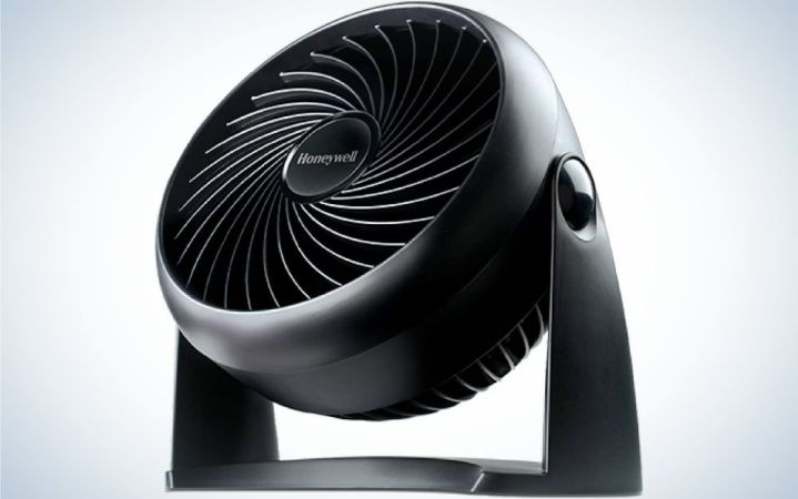  A portable all black color desk fan with an upper round shape and with flat shape under it.