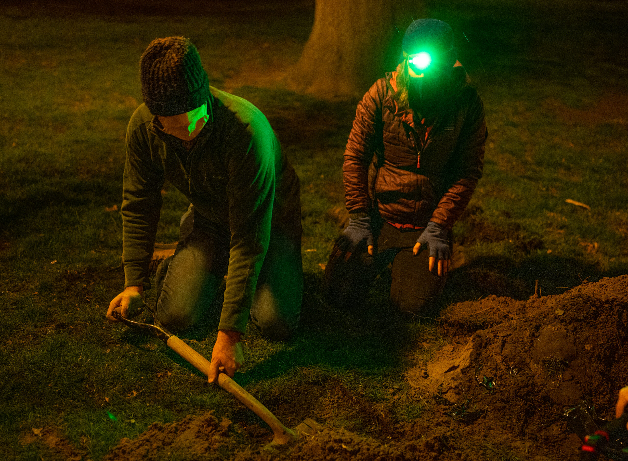 Two scientists dig with a shovel.