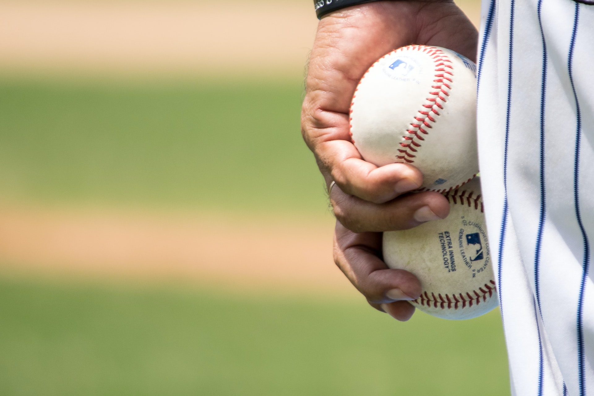 Player in pinstripes holding two baseballs