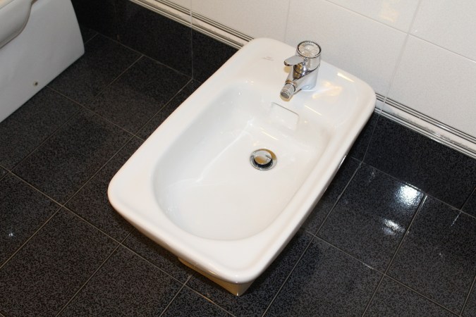 Bidet in a bathroom with a black tile floor