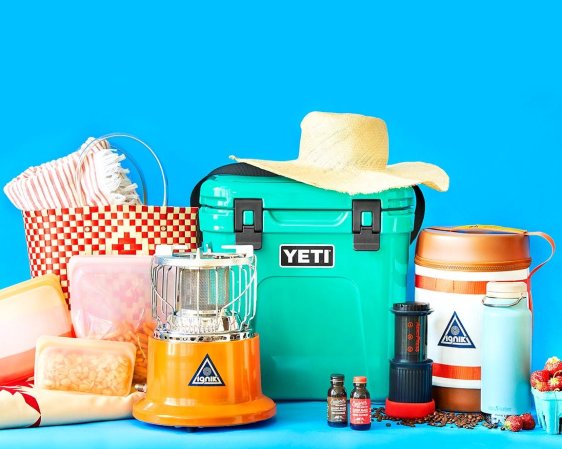 Teal Yeti cooler and other travel gear on a blue background