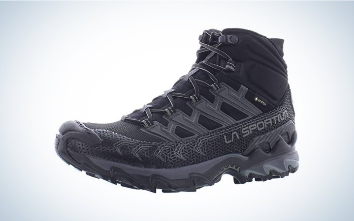  A pair of black backpacking hiking shoes on a blue and white background