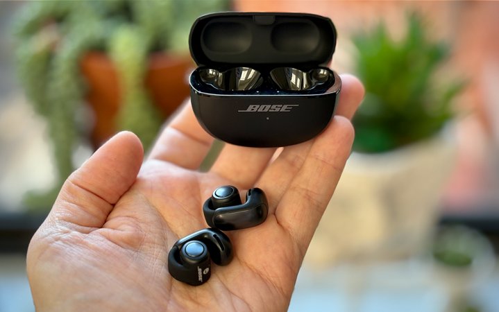  Black Bose Ultra Open earbuds in my palm holding their open case