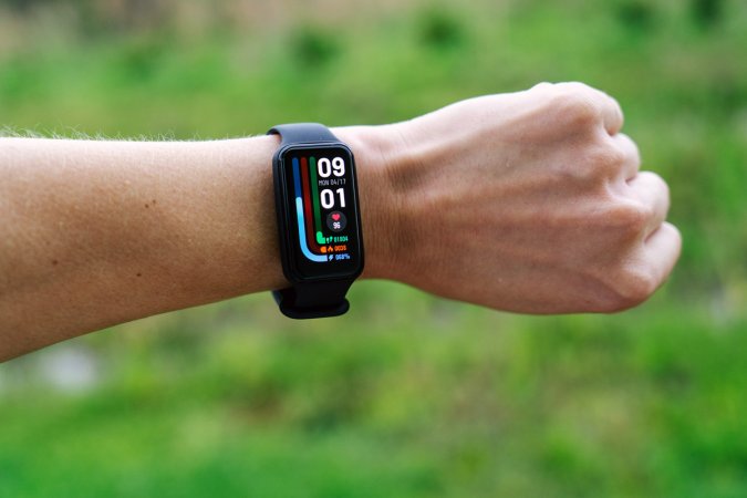  Amazfit Band 7 budget fitness tracker on a wrist with a green background