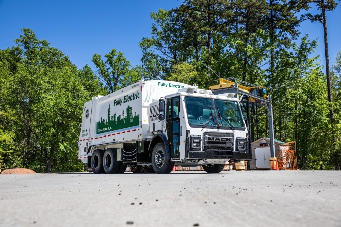 an electric garbage truck in a parking lot