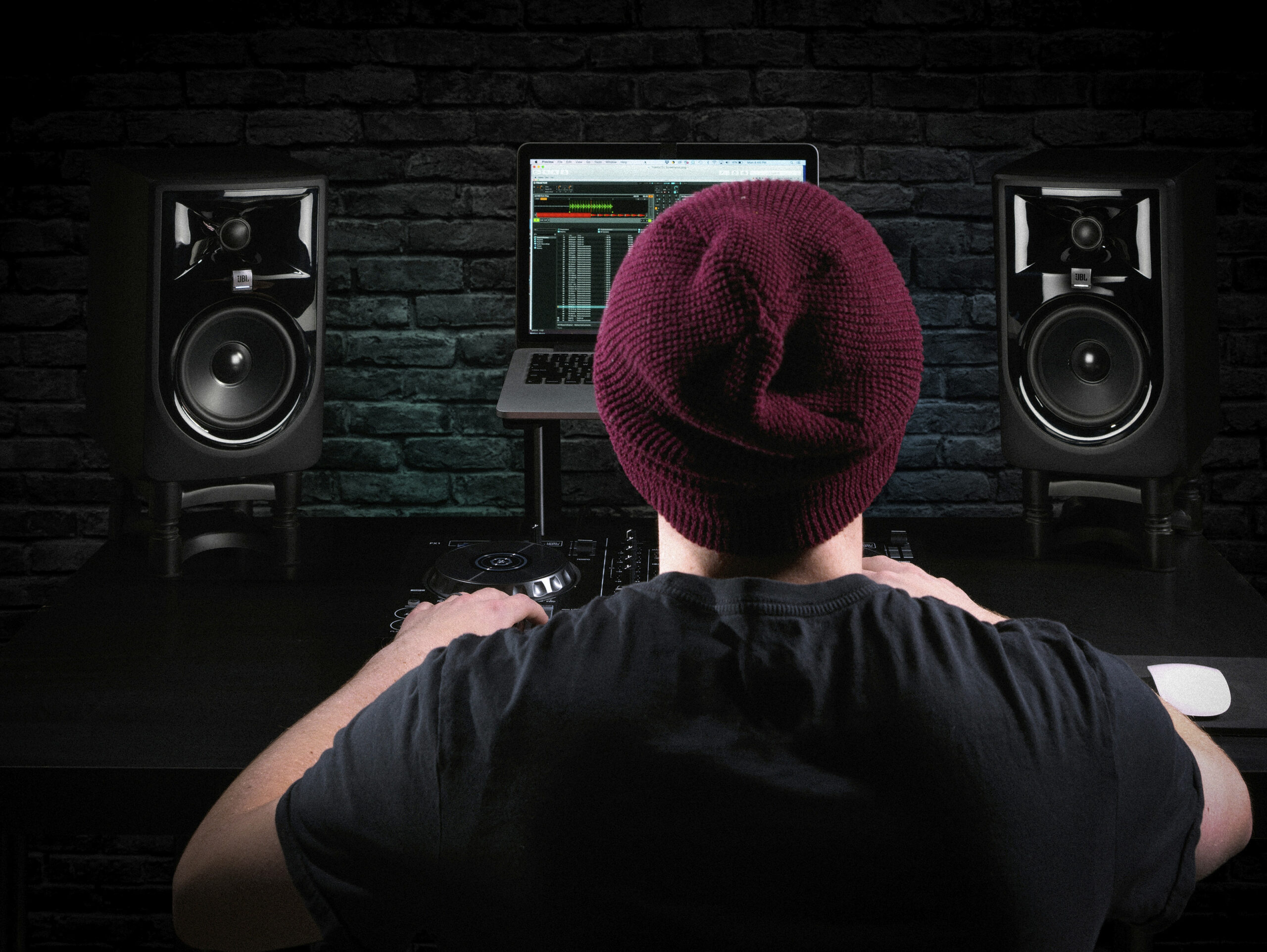 DJ/producer in a home studio with JBL monitors