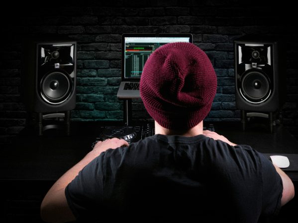 DJ/producer in a home studio with JBL monitors