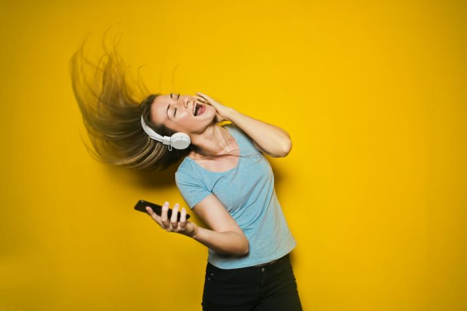 Happy lady listening to Bluetooth headphones