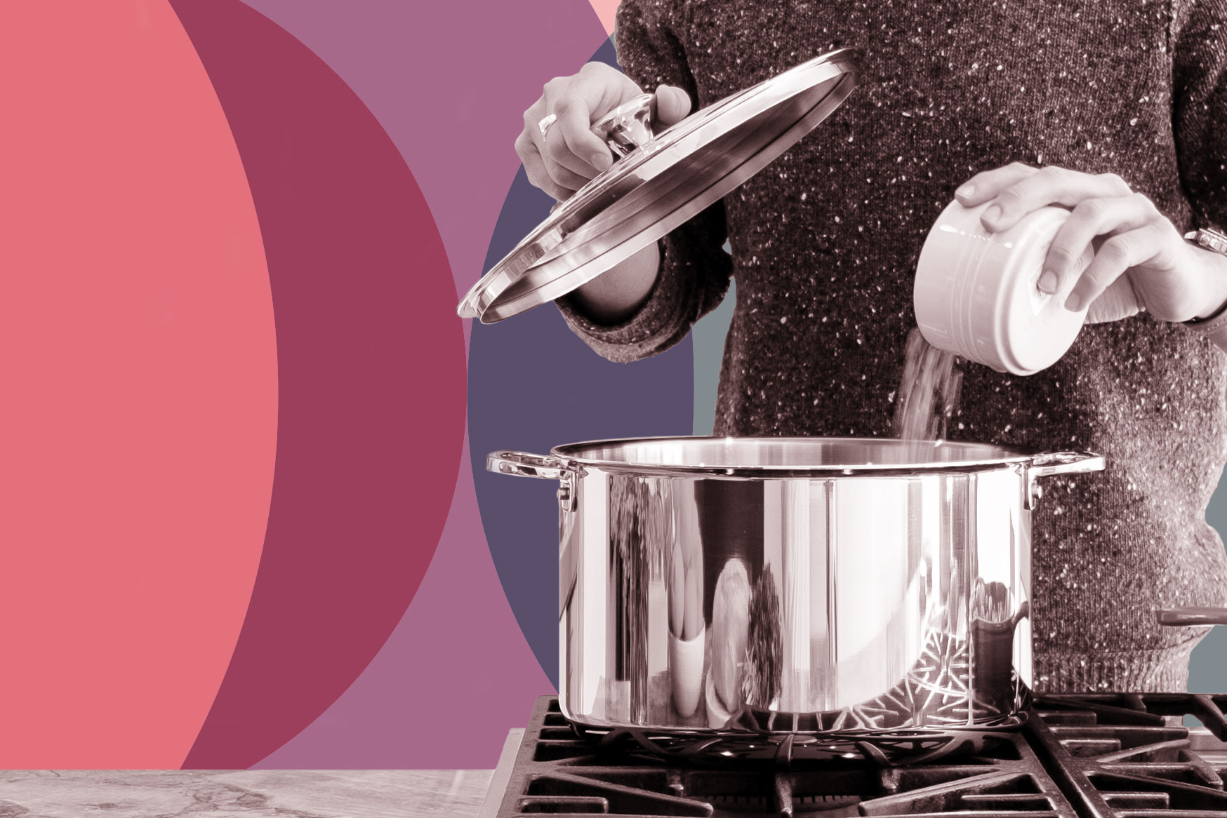 A person pouring a bunch of salt into a metal cooking pot on a gas stove.