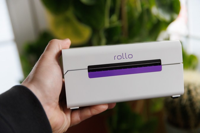  Rollo label printer in front of plants being held in a hand