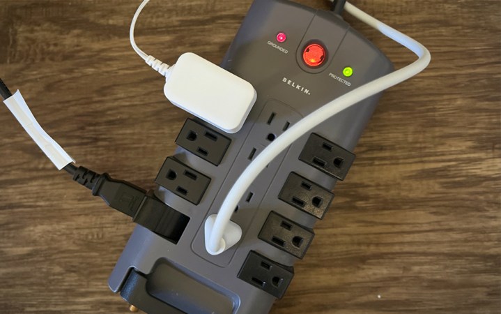  A black Belkin Pivot Plug surge protector on a wood floor.